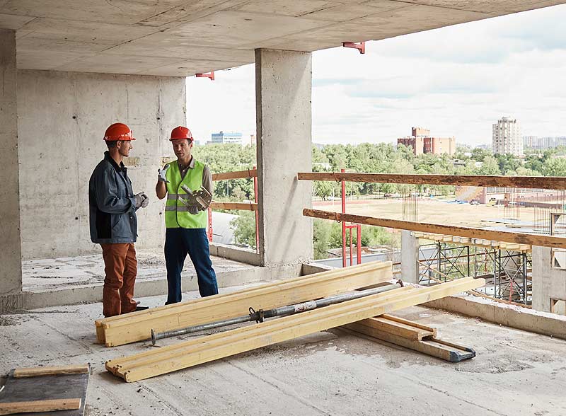 Deux ouvriers font un point sur le chantier.