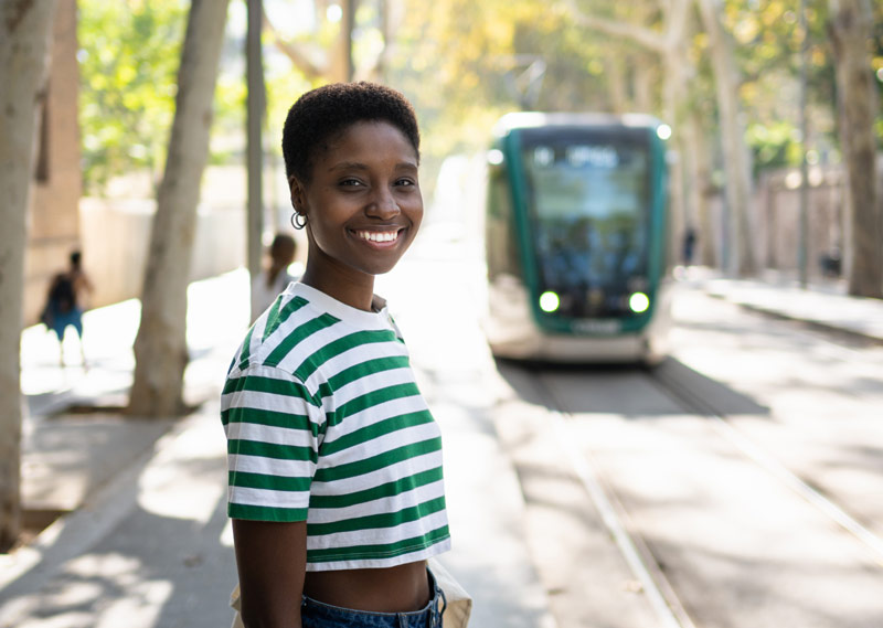 Jeune femme afro attend son métro à la station.