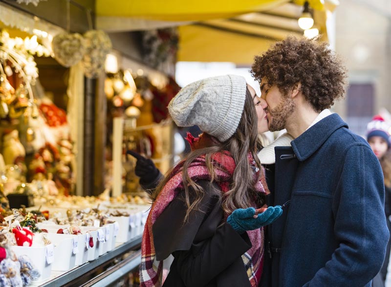 Couple s'embrasse au marché de Noël