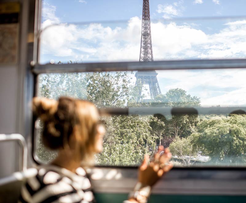 Jeune femme contemple la tour Eiffel depuis le métro parisien.